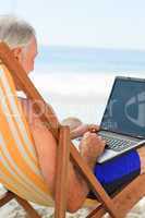 Man working on his laptop at the beach