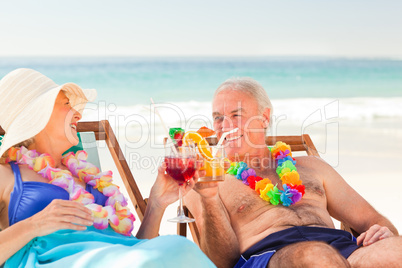 Couple drinking cocktails at the beach