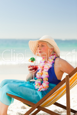 Woman drinking a cocktail in her deck chair