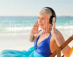 Retired woman listening to music at the beach