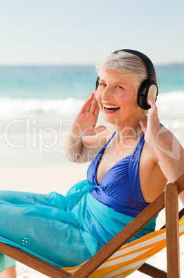 Retired woman listening to music at the beach