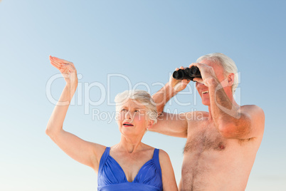 Elderly couple bird watching at the beach