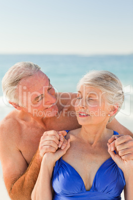 Man hugging his wife at the beach