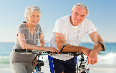 Retired couple with their bikes on the beach