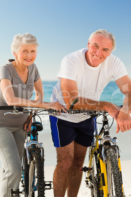 Retired couple with their bikes on the beach