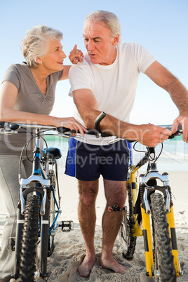 Retired couple with their bikes on the beach