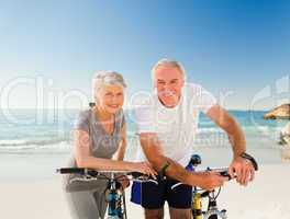 Retired couple with their bikes on the beach