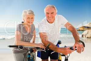 Retired couple with their bikes on the beach