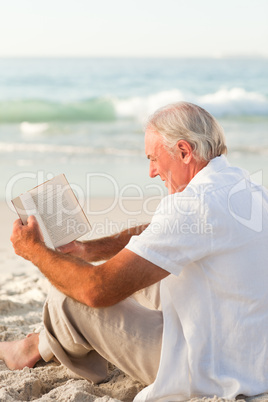 Man reading a book on the beach