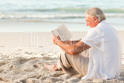 Man reading a book on the beach