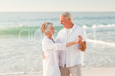 Elderly couple dancing on the beach