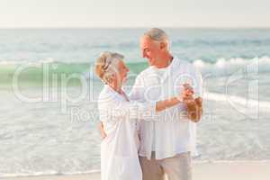 Elderly couple dancing on the beach