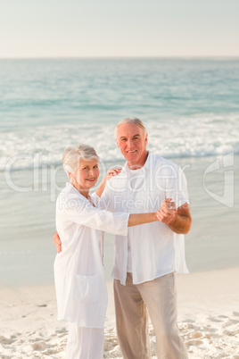 Elderly couple dancing on the beach