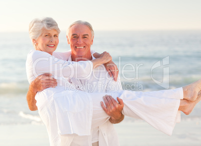 Man carrying his wife on the beach
