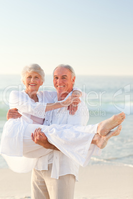 Man carrying his wife on the beach