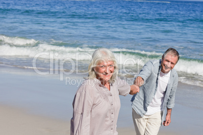 Elderly couple walking on the beach