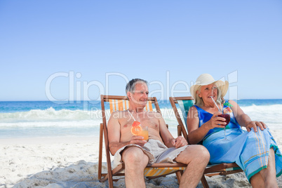 Senior couple sitting on deck chairs