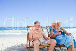 Senior couple sitting on deck chairs