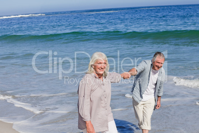 Elderly couple walking on the beach Elderly couple walking on the beach
