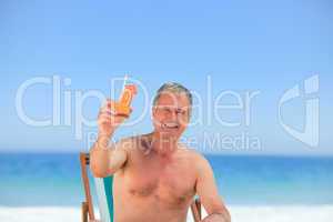 Senior man drinking a cocktail on the beach