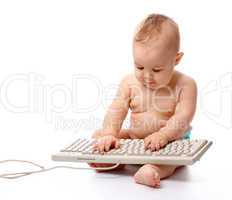 Little child is typing on keyboard