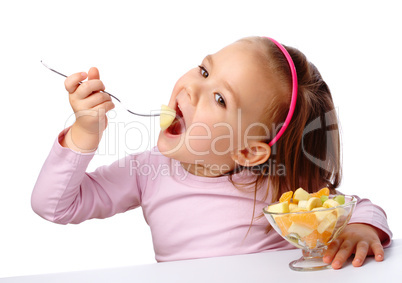 Little girl eats fruit salad