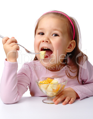 Little girl eats fruit salad