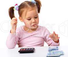 Little girl plays with money