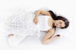 Young woman sleeping on white bed