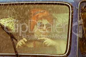 Vintage girl driving car under rain