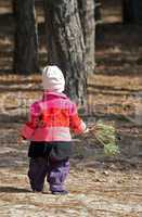 Kid walking with pine branch