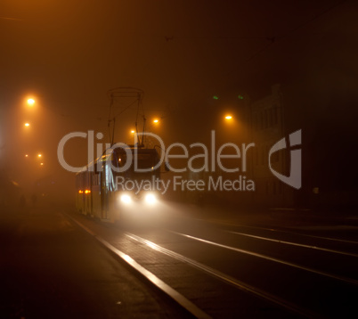 Tram moving on city street in the fog