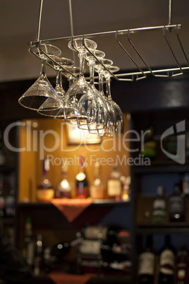 Wine glasses hanging near bar counter