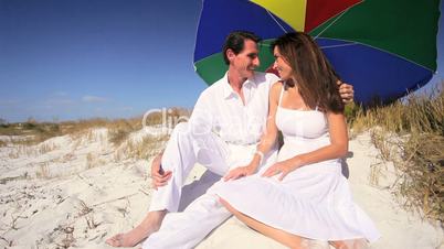 Couple Sitting Under Beach Parasol