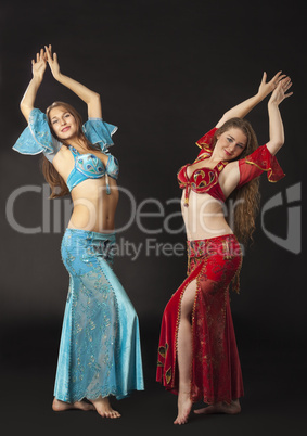Two woman dance and smile in arabian costume