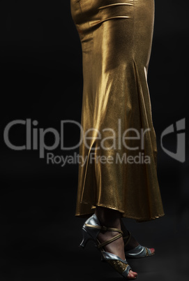 Woman legs in gold dress