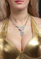 Woman breast in gold costume with jewellery