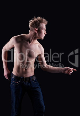 Young naked man in jeans posing on black