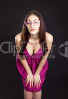 Pretty young girl in red dress posing in studioon dark backgroun