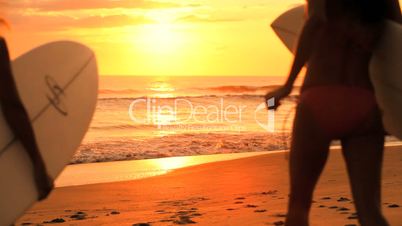 Beautiful Girls with Surfboards at Sunrise