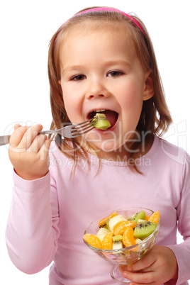 Little girl eats fruit salad