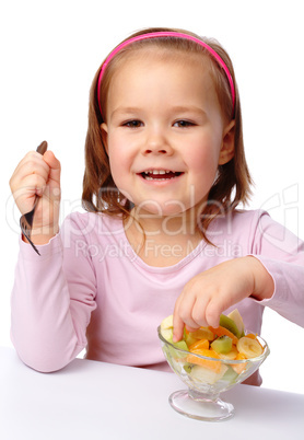 Little girl eats fruit salad