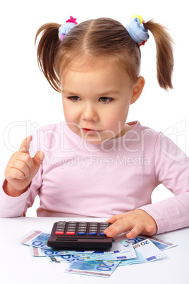 Little girl plays with money