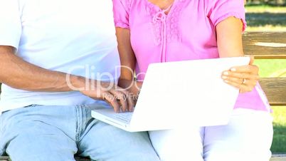 Attractive Senior Couple Using Laptop Outdoors