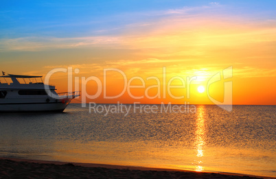 ship at anchor and sunrise over sea