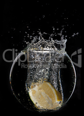 Yellow lemon half in water splash on dark background