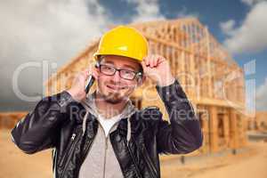 Young Cunstruction Worker on Cell Phone In Front of House