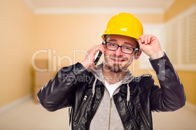 Young Contractor Wearing Hard Hat on Cell Phone In House