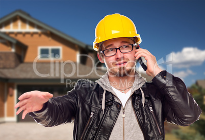 Contractor Wearing Hard Hat on Phone In Front of House Contractor Wearing Hard Hat on Phone In Front of House