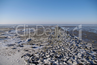 Wattenmeer mit vereister Strandbefestigung bei Ebbe an der Nordsee